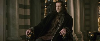 Movie still from “The Twilight Saga: New Moon” (2009), directed by Chris Weitz – A man sitting in a chair wearing a black coat; Medium shot, High angle