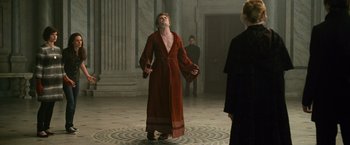 Movie still from “The Twilight Saga: New Moon” (2009), directed by Chris Weitz – A man in a robe stands in front of two other people; Medium shot, Low angle