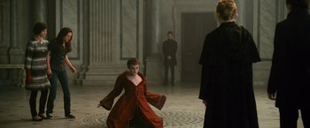 Movie still from “The Twilight Saga: New Moon” (2009), directed by Chris Weitz – A woman in a red dress in front of two men in black suits; Wide shot, Over the shoulder angle