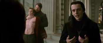Movie still from “The Twilight Saga: New Moon” (2009), directed by Chris Weitz – A man and a woman standing next to each other in front of a building; Medium shot, Over the shoulder angle
