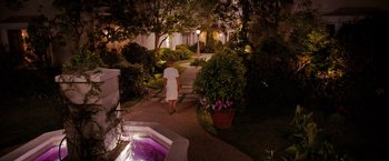 Movie still from “The Ugly Truth” (2009), directed by Robert Luketic – A man walking down a path at night near a fountain; Extreme Wide shot, High angle