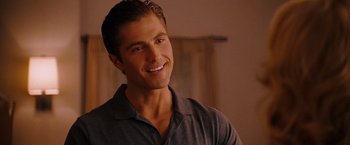 Movie still from “The Ugly Truth” (2009), directed by Robert Luketic – A person wearing a gray shirt smiling; Close Up shot, Over the shoulder angle