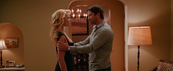 Movie still from “The Ugly Truth” (2009), directed by Robert Luketic – A man and a woman standing next to each other in front of a chandelier; Medium shot, Over the shoulder angle