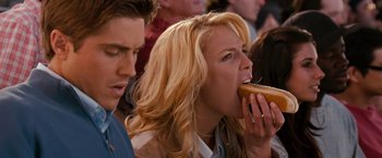 Movie still from “The Ugly Truth” (2009), directed by Robert Luketic – A woman is eating a hot dog while a man looks on; Close Up shot, Over the shoulder angle