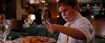Movie still from “The Ugly Truth” (2009), directed by Robert Luketic – A young boy in a tie is eating pasta; Close Up shot, Over the shoulder angle