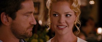Movie still from “The Ugly Truth” (2009), directed by Robert Luketic – A man and a woman smiling at each other in front of some fruit; Close Up shot, Over the shoulder angle