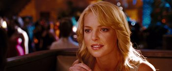 Movie still from “The Ugly Truth” (2009), directed by Robert Luketic – A woman with blonde hair sitting at a table in a restaurant; Close Up shot, Over the shoulder angle