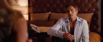 Movie still from “The Ugly Truth” (2009), directed by Robert Luketic – A man sitting on the ground in a room; Medium shot, Over the shoulder angle