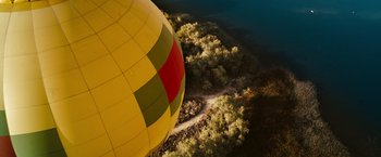Movie still from “The Ugly Truth” (2009), directed by Robert Luketic – An aerial view of a hot air balloon flying over a forest; Extreme Wide shot, Overhead angle