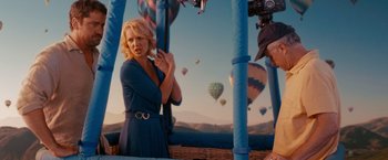 Movie still from “The Ugly Truth” (2009), directed by Robert Luketic – A woman in a blue dress standing in front of balloons; Medium shot, Over the shoulder angle
