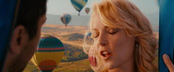 Movie still from “The Ugly Truth” (2009), directed by Robert Luketic – A woman with blonde curly hair is in a field with hot air balloons; Close Up shot, Overhead angle