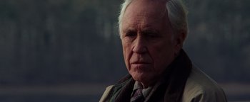 Movie still from “Enemy of the State” (1998), directed by Tony Scott – An older man wearing a neck tie and a jacket; Close Up shot, Low angle