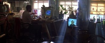 Movie still from “Enemy of the State” (1998), directed by Tony Scott – Two people sitting in front of a computer monitor; Wide shot, Low angle