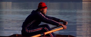 Movie still from “Enemy of the State” (1998), directed by Tony Scott – A man rowing a boat on a body of water; Medium shot, High angle