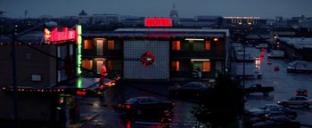 Movie still from “Enemy of the State” (1998), directed by Tony Scott – A motel lit up for the holiday season; Extreme Wide shot, Low angle