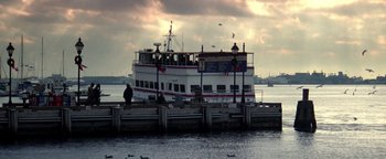 Movie still from “Enemy of the State” (1998), directed by Tony Scott – A boat is docked at a pier on a cloudy day; Extreme Wide shot, Low angle