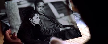 Movie still from “Enemy of the State” (1998), directed by Tony Scott – A black and white photo of a man and a woman sitting together; Close Up shot, High angle
