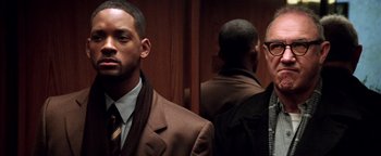 Movie still from “Enemy of the State” (1998), directed by Tony Scott – A man in a suit and tie standing next to another man in a suit and tie; Close Up shot, Low angle