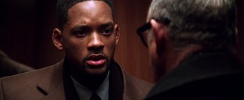 Movie still from “Enemy of the State” (1998), directed by Tony Scott – A man wearing a suit and tie talking to another man; Close Up shot, Over the shoulder angle