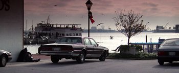 Movie still from “Enemy of the State” (1998), directed by Tony Scott – A car parked on the side of the road next to the water; Extreme Wide shot, Low angle