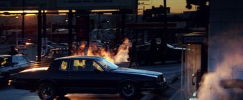 Movie still from “Enemy of the State” (1998), directed by Tony Scott – A car on a city street with smoke coming out of the windows; Wide shot, High angle