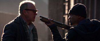 Movie still from “Enemy of the State” (1998), directed by Tony Scott – A man is holding a rifle and a man is holding a gun; Close Up shot, Over the shoulder angle