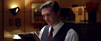 Movie still from “Enemy of the State” (1998), directed by Tony Scott – A man in a vest and tie reading a newspaper; Close Up shot, Low angle