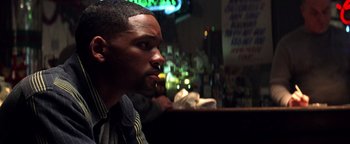 Movie still from “Enemy of the State” (1998), directed by Tony Scott – A person sitting at a bar; Close Up shot, Over the shoulder angle