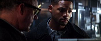 Movie still from “Enemy of the State” (1998), directed by Tony Scott – A man looking at a computer screen while another man looks on; Close Up shot, Over the shoulder angle