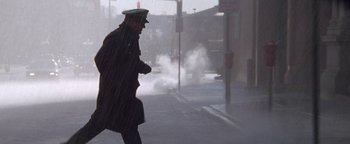 Movie still from “Enemy of the State” (1998), directed by Tony Scott – A man walking down a street in the fog; Wide shot, Low angle