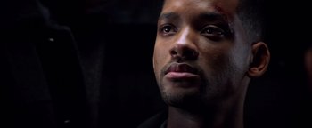 Movie still from “Enemy of the State” (1998), directed by Tony Scott – A person with a scar on his face; Close Up shot, Low angle