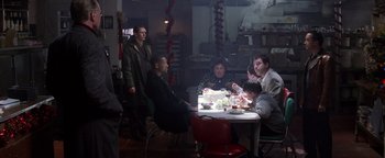 Movie still from “Enemy of the State” (1998), directed by Tony Scott – A group of people sitting around a table eating; Wide shot, High angle