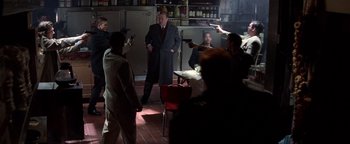 Movie still from “Enemy of the State” (1998), directed by Tony Scott – A group of people in a room holding guns; Wide shot, High angle
