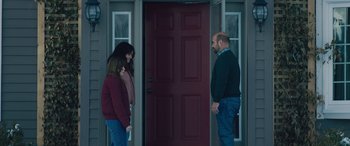 Movie still from “The Ultimate Playlist of Noise” (2021), directed by Bennett Lasseter – Three people are standing in front of a red door; Medium shot, Over the shoulder angle