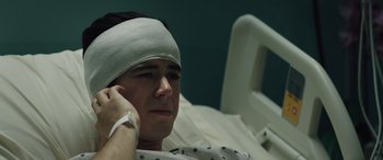 Movie still from “The Ultimate Playlist of Noise” (2021), directed by Bennett Lasseter – A man with bandages on his head in a hospital bed; Close Up shot, High angle