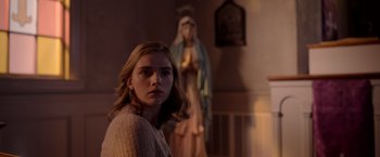 Movie still from “The Unholy” (2021), directed by Evan Spiliotopoulos – A woman standing in front of a statue of mary; Close Up shot, Low angle