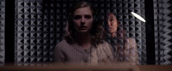 Movie still from “The Unholy” (2021), directed by Evan Spiliotopoulos – A woman wearing headphones in front of a wall; Close Up shot, Over the shoulder angle