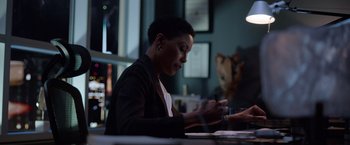Movie still from “The Unholy” (2021), directed by Evan Spiliotopoulos – A woman sitting at a table with a cell phone in her hand; Medium shot, Low angle