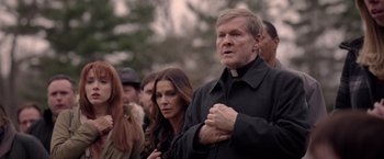 Movie still from “The Unholy” (2021), directed by Evan Spiliotopoulos – A man and woman standing next to each other in front of a crowd of onlookers; Close Up shot, Over the shoulder angle