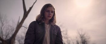 Movie still from “The Unholy” (2021), directed by Evan Spiliotopoulos – A young woman is standing in a field; Medium shot, Low angle