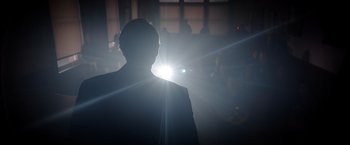 Movie still from “The Unholy” (2021), directed by Evan Spiliotopoulos – A man standing in a room in front of a crowd; Medium shot, Low angle