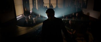 Movie still from “The Unholy” (2021), directed by Evan Spiliotopoulos – A man in a black suit standing in front of a group of people; Wide shot, Low angle