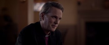 Movie still from “The Unholy” (2021), directed by Evan Spiliotopoulos – A person wearing a suit and tie; Close Up shot, Over the shoulder angle