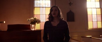 Movie still from “The Unholy” (2021), directed by Evan Spiliotopoulos – A woman standing in front of a stained glass window; Medium shot, Over the shoulder angle