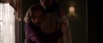 Movie still from “The Unholy” (2021), directed by Evan Spiliotopoulos – A man and a woman hugging each other in a dark room; Medium shot, Over the shoulder angle