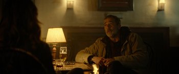 Movie still from “The Unholy” (2021), directed by Evan Spiliotopoulos – A man sitting at a table in a dimly - lit room; Medium shot, Over the shoulder angle