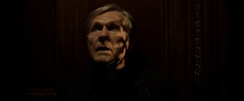 Movie still from “The Unholy” (2021), directed by Evan Spiliotopoulos – An old man with a beard is looking at the camera; Close Up shot, Low angle