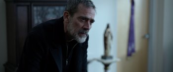 Movie still from “The Unholy” (2021), directed by Evan Spiliotopoulos – An older man in a black jacket looking at the camera; Close Up shot, Over the shoulder angle