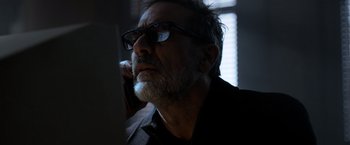 Movie still from “The Unholy” (2021), directed by Evan Spiliotopoulos – An older man with a beard wearing glasses and talking on the phone; Close Up shot, Low angle