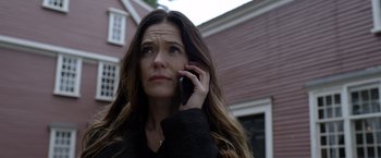 Movie still from “The Unholy” (2021), directed by Evan Spiliotopoulos – A woman talking on a cell phone while standing in front of a house; Close Up shot, Low angle